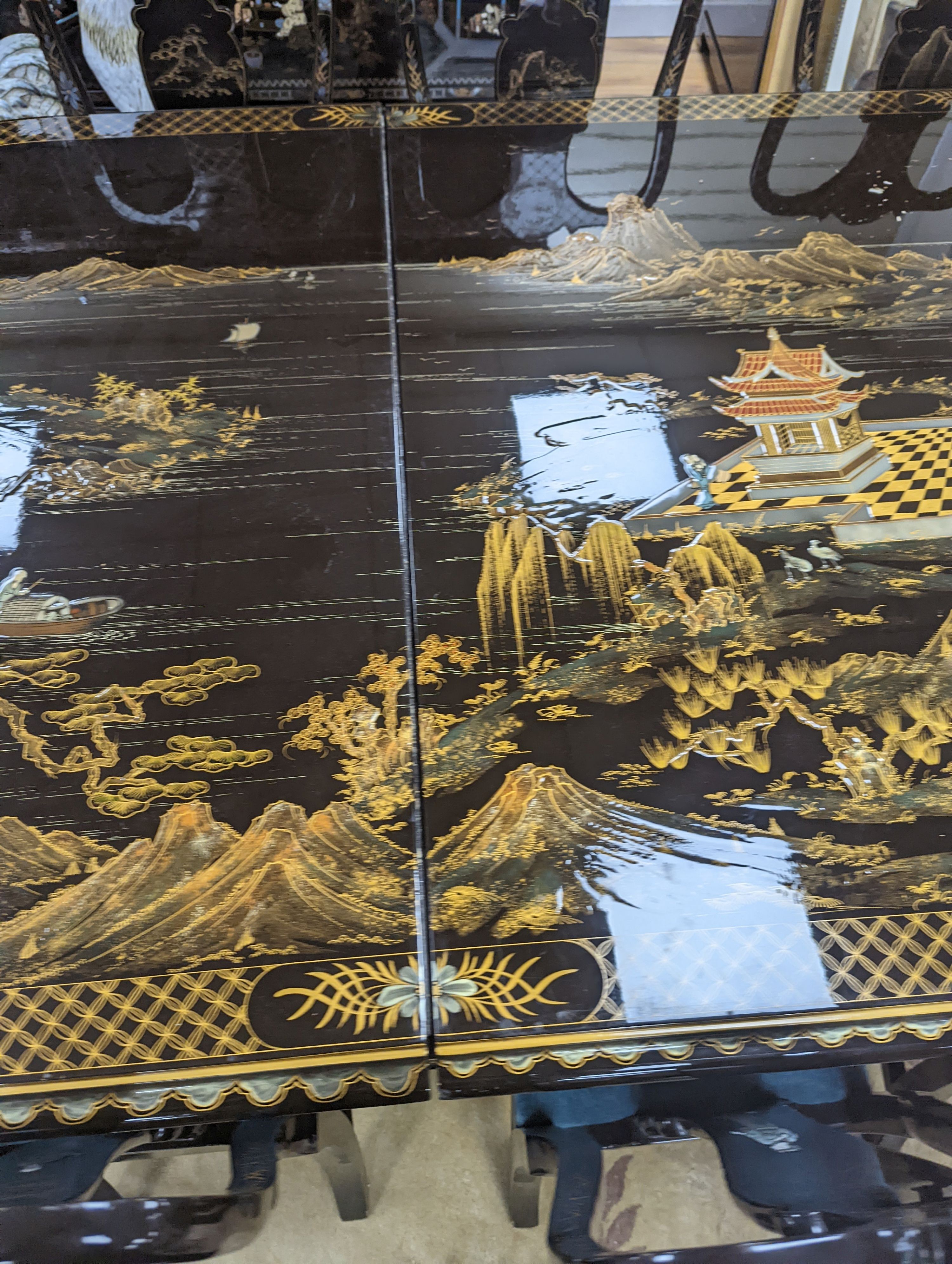 A Chinese lacquer decorated dining table and 12 chairs. Length -277cm, Depth- 120cm, Height - 74cm.